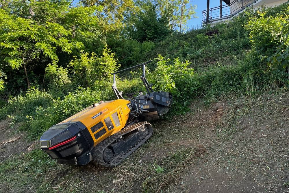 Ferngesteuerte Mulchraupe beim Mulchen eines steilen Hangs